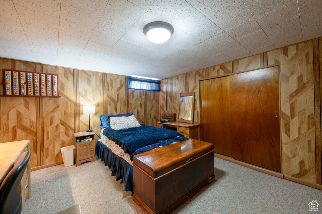 Carpeted bedroom with wood walls