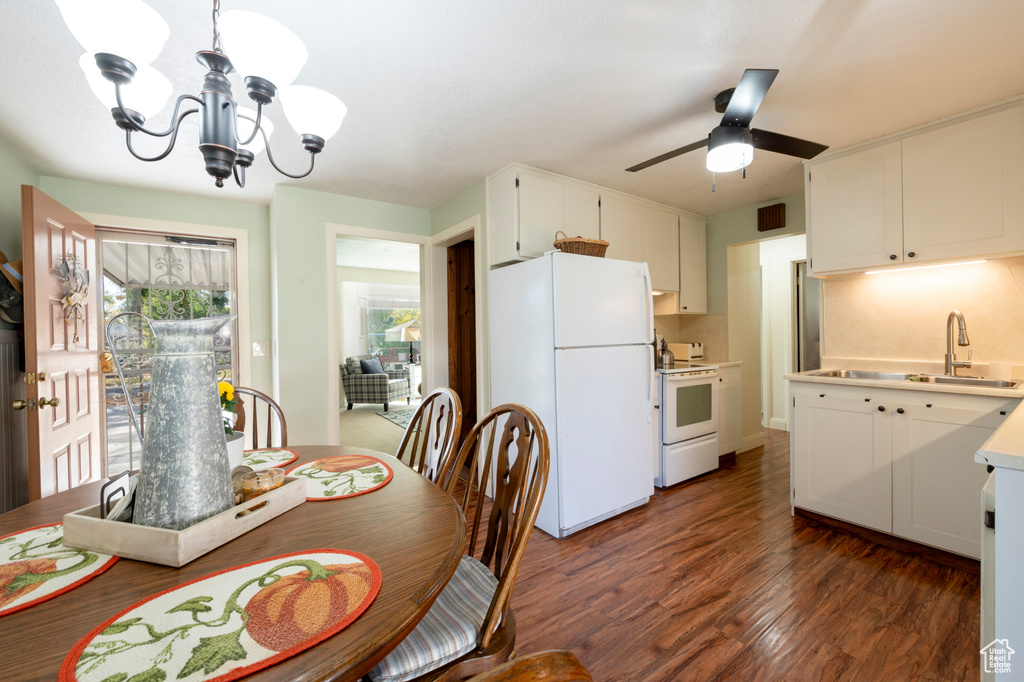 Dining area with dark hardwood / wood-style floors, sink, and ceiling fan with notable chandelier