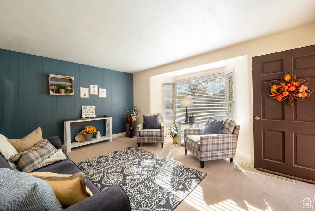 Living room with wood walls and light colored carpet