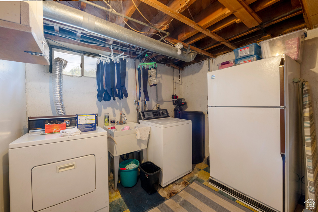 Clothes washing area featuring washer and dryer and sink