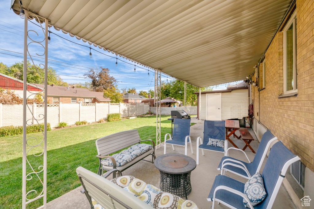 View of patio with a storage unit