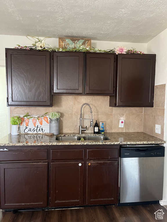 Kitchen featuring dark hardwood / wood-style flooring, dark brown cabinetry, sink, and dishwasher