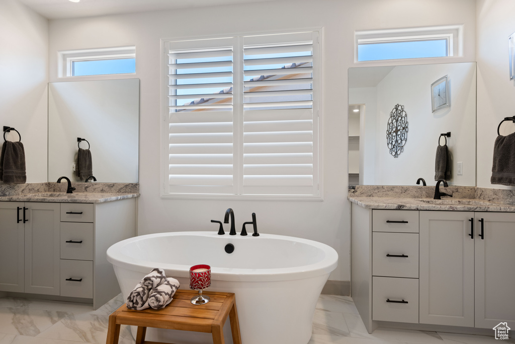 Bathroom with vanity, a tub, and plenty of natural light