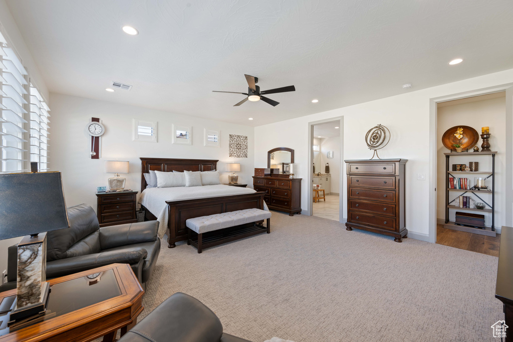 Bedroom with ensuite bath, light wood-type flooring, and ceiling fan