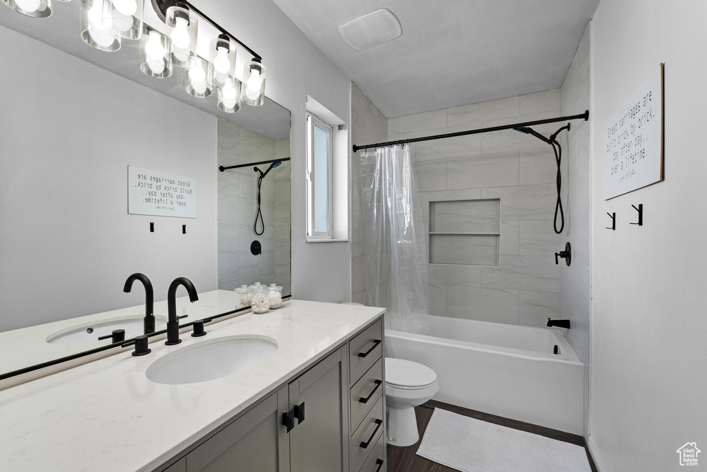 Full bathroom featuring vanity, toilet, shower / bath combo, and hardwood / wood-style floors