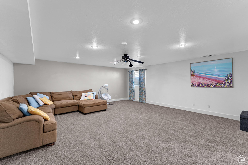 Carpeted living room with ceiling fan