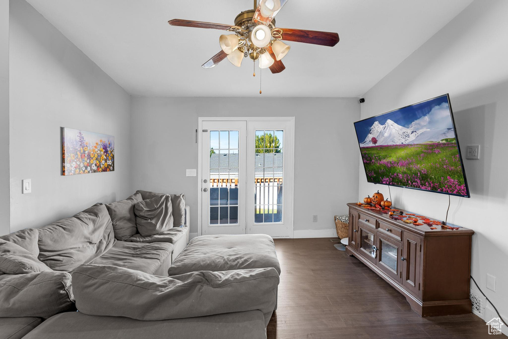 Living room featuring vaulted ceiling, ceiling fan, and dark hardwood / wood-style flooring