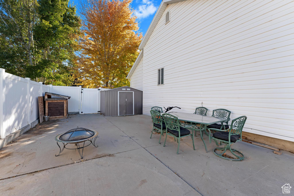 View of patio / terrace featuring a shed and a fire pit