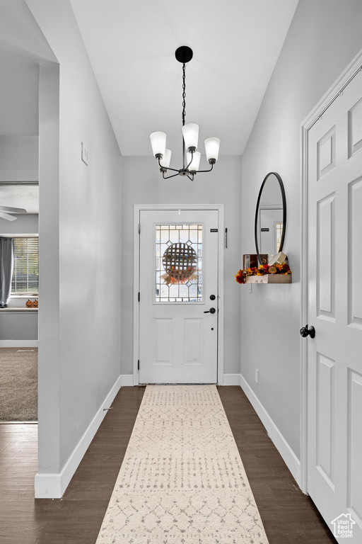 Entrance foyer featuring a notable chandelier, a healthy amount of sunlight, and dark hardwood / wood-style flooring