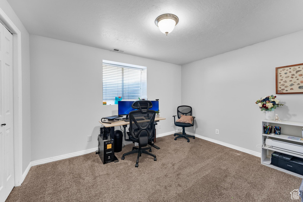 Home office with carpet and a textured ceiling