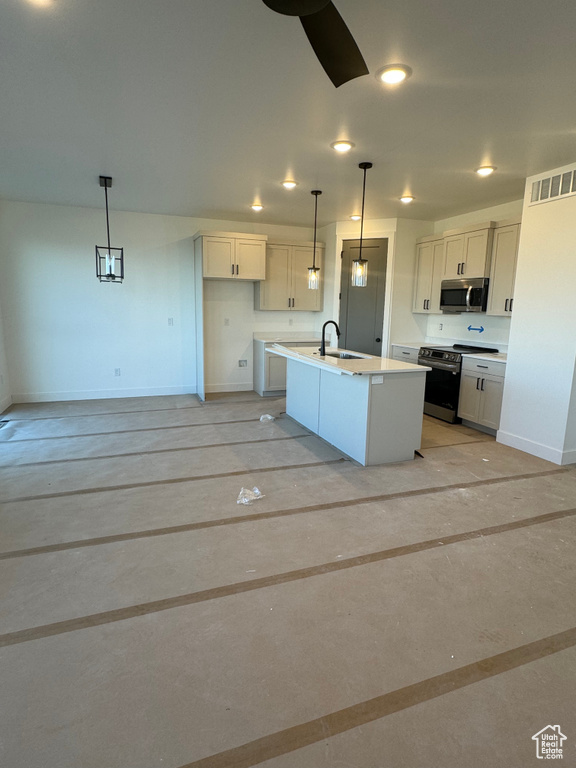 Kitchen with stainless steel appliances, a center island with sink, sink, pendant lighting, and white cabinetry