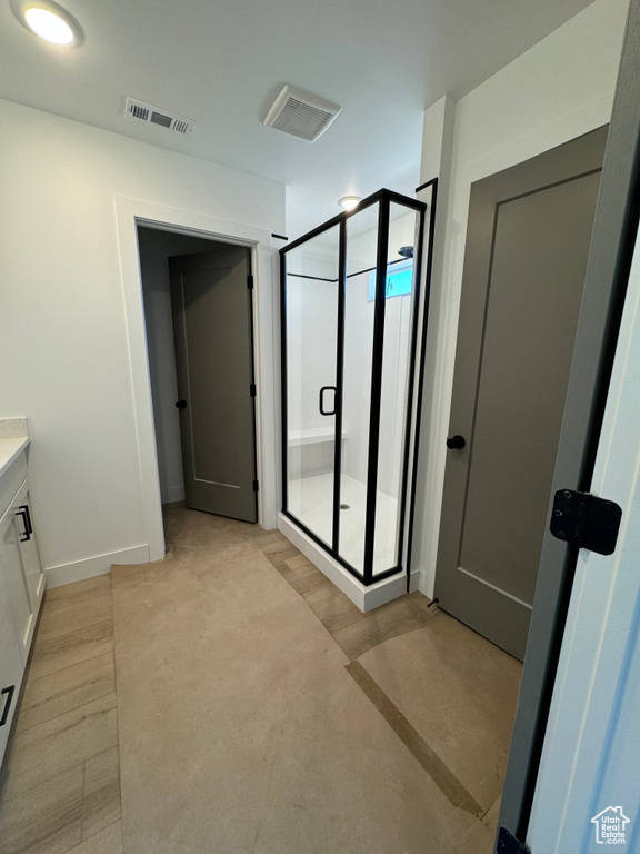 Bathroom with vanity and a shower with shower door