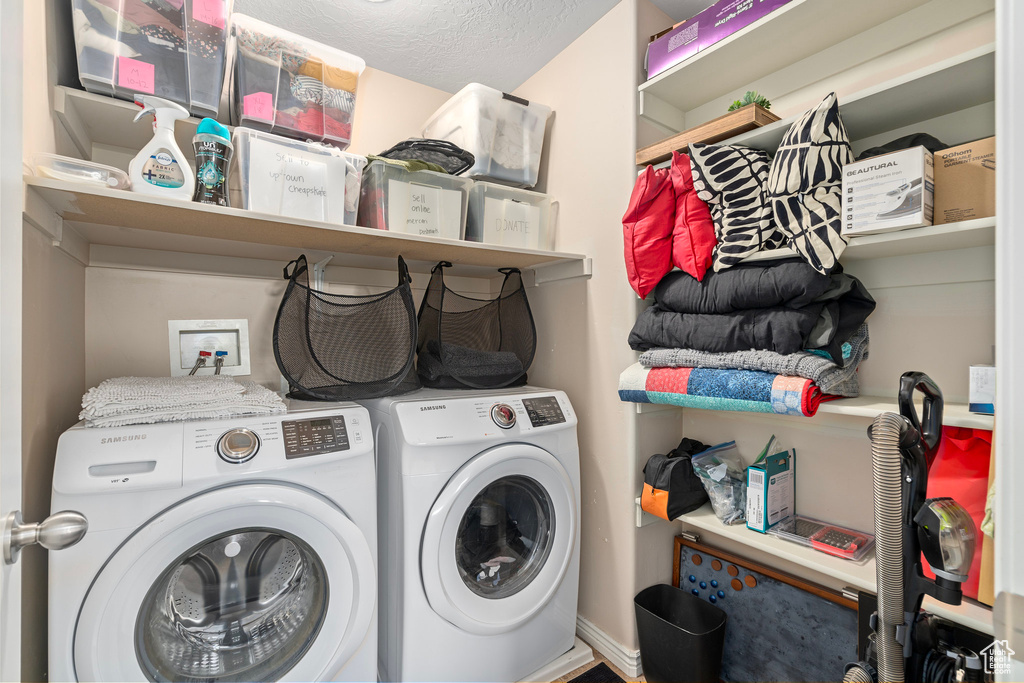 Laundry room with a textured ceiling and washing machine and clothes dryer