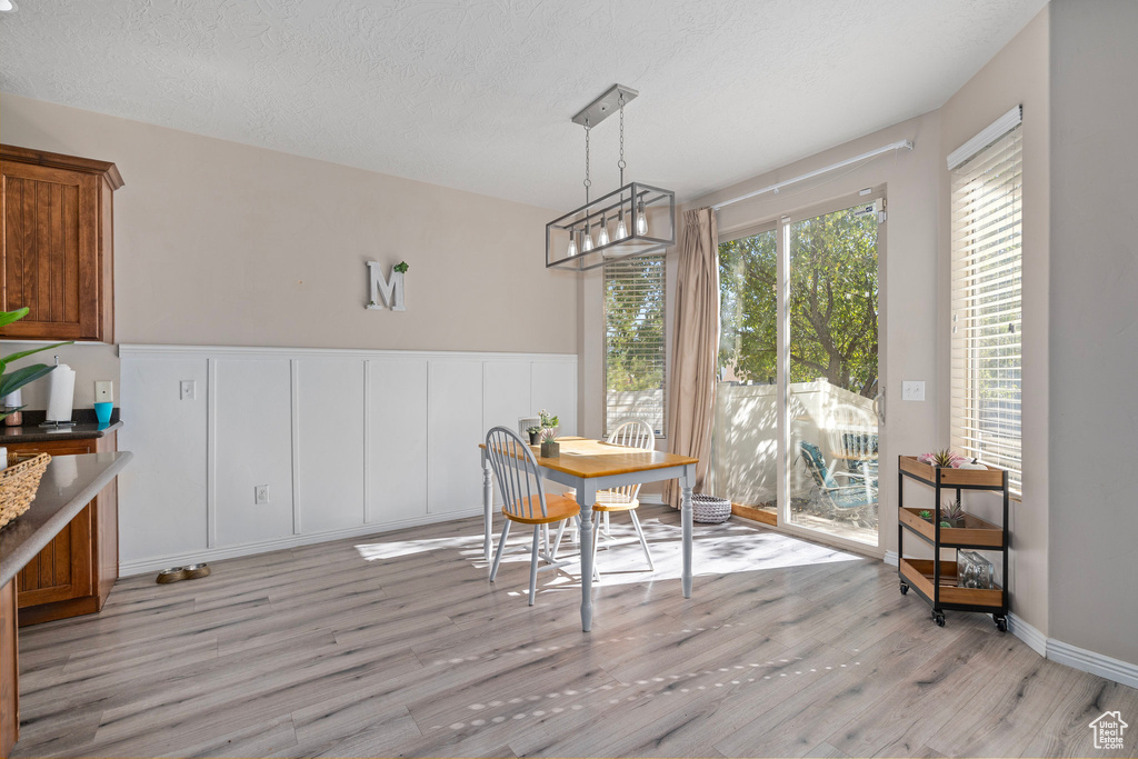 Dining room with a textured ceiling and light hardwood / wood-style flooring