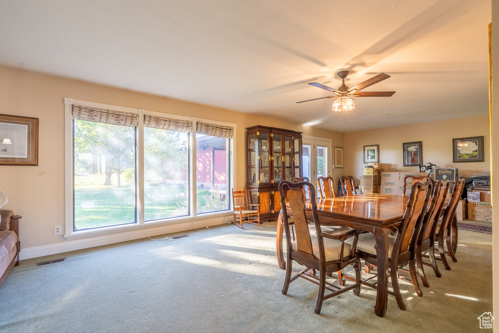 Dining room featuring ceiling fan and light carpet