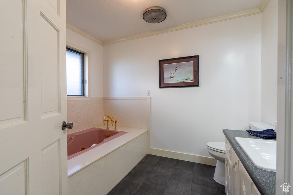 Bathroom featuring vanity, a tub to relax in, crown molding, and toilet