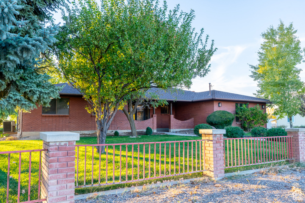 View of front of home featuring a front lawn and central AC unit