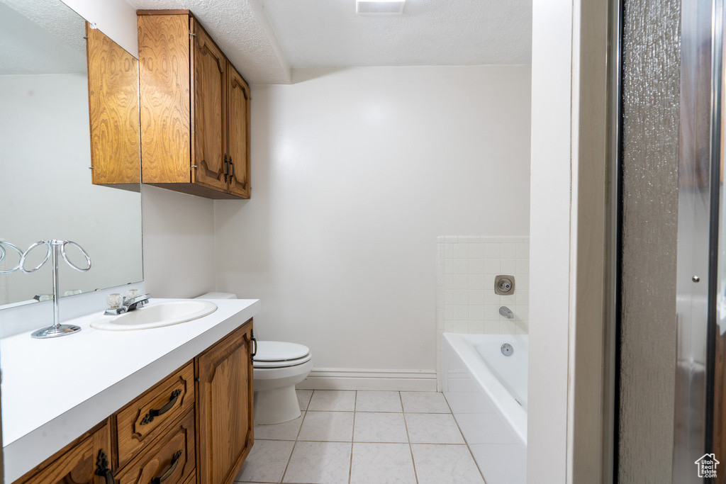 Full bathroom with vanity, toilet, tile patterned floors, and separate shower and tub