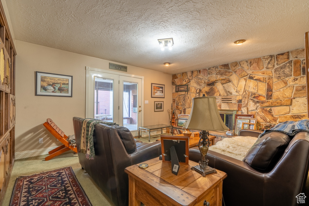 Carpeted living room featuring french doors and a textured ceiling