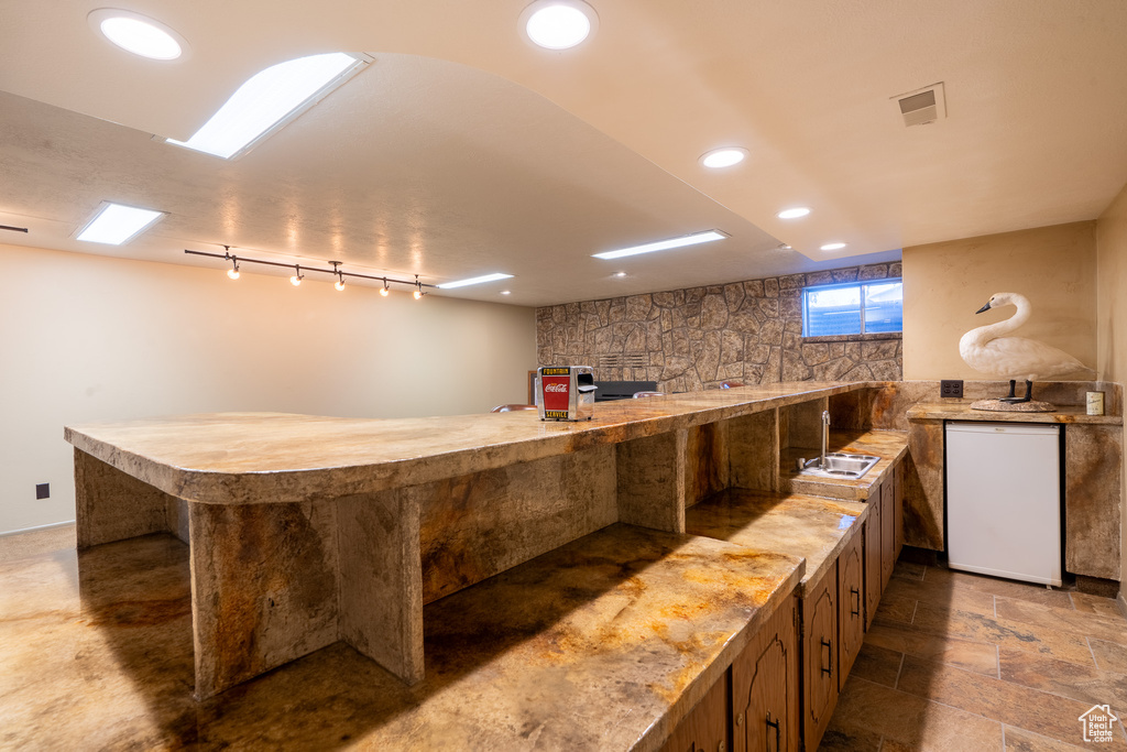 Bar with white appliances and sink