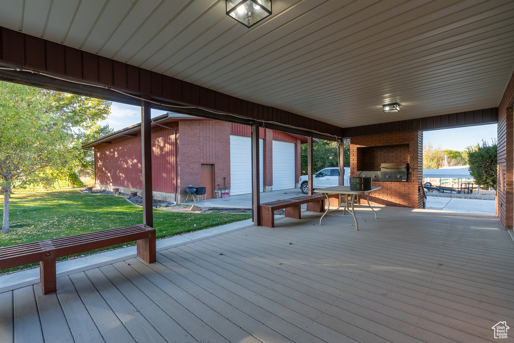 Wooden terrace with a yard and an outdoor brick fireplace