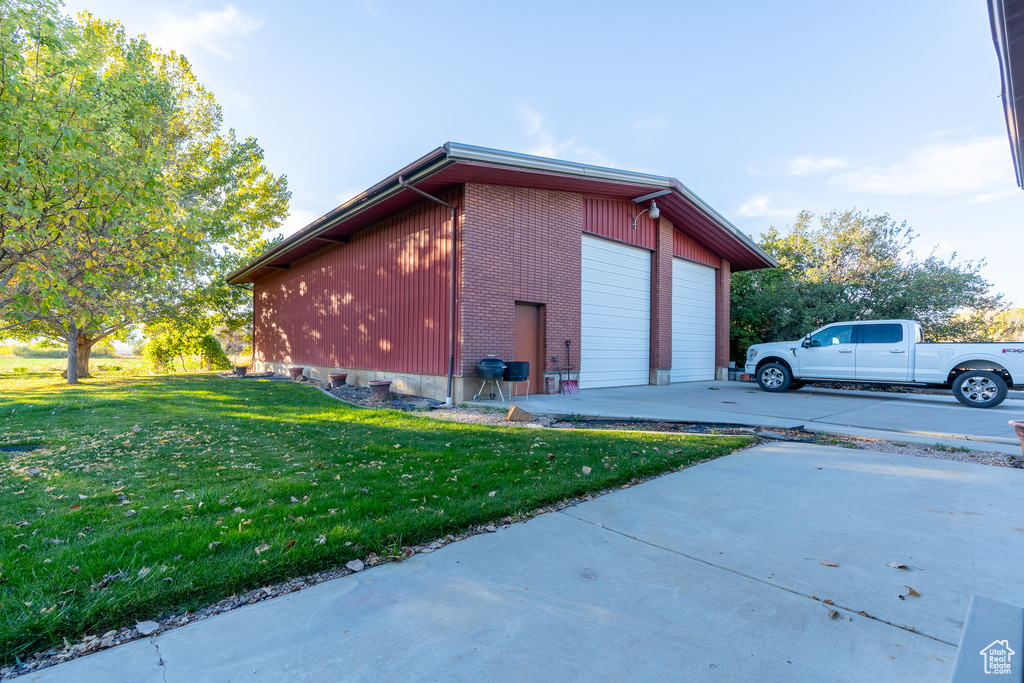 View of side of home with a yard and a garage