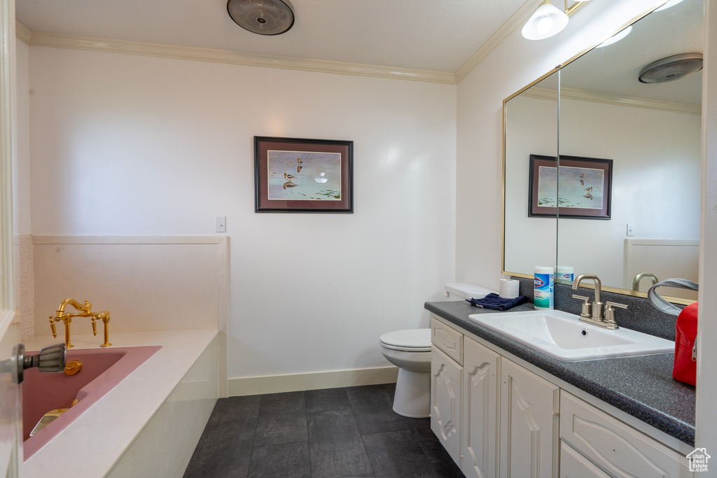 Bathroom featuring vanity, crown molding, toilet, and a bathtub