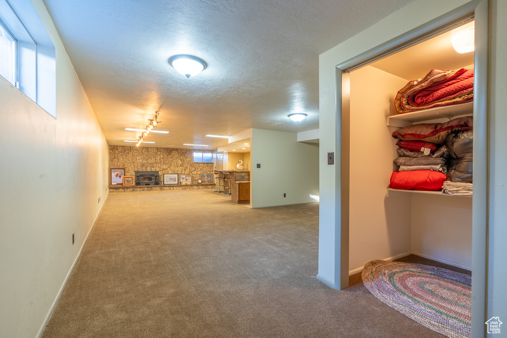 Interior space featuring rail lighting, light carpet, and a textured ceiling