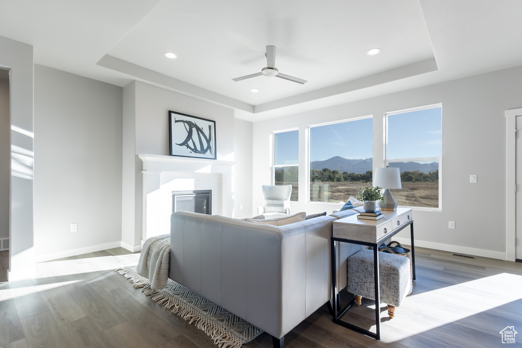 Living room featuring a mountain view, wood-type flooring, and ceiling fan