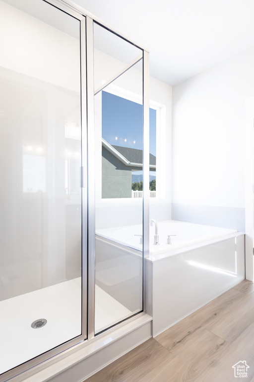 Bathroom featuring hardwood / wood-style floors and independent shower and bath