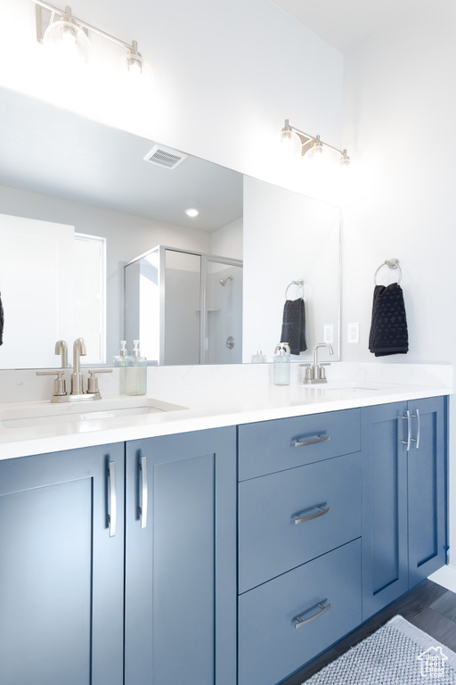 Full bath with double vanity, visible vents, and a sink