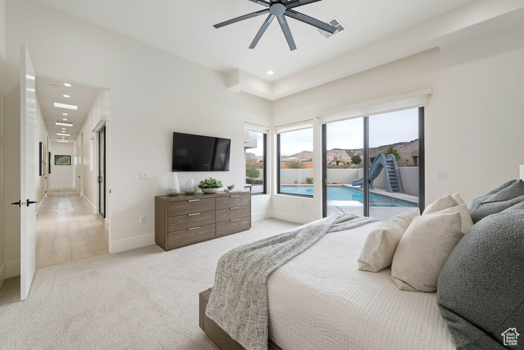 Bedroom featuring ceiling fan, light carpet, and access to outside