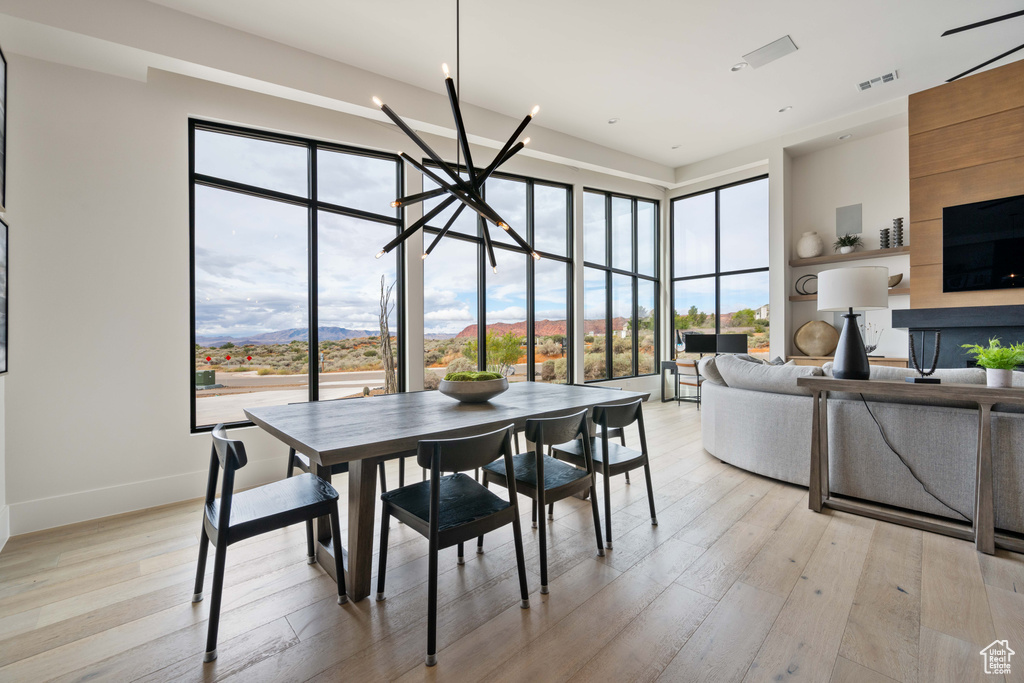 Dining area with an inviting chandelier, light hardwood / wood-style flooring, and plenty of natural light