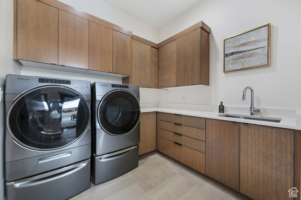 Laundry area with sink, washing machine and dryer, and cabinets