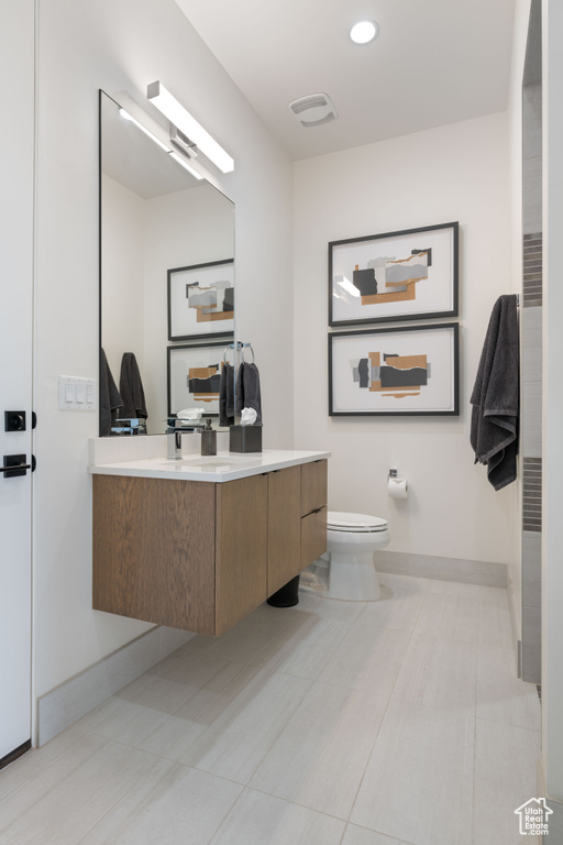 Bathroom with vanity, toilet, and tile patterned floors