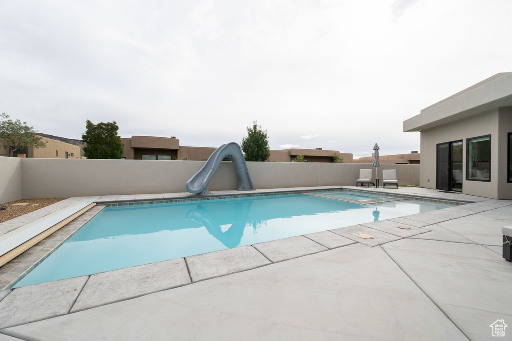 View of swimming pool featuring a patio and a water slide