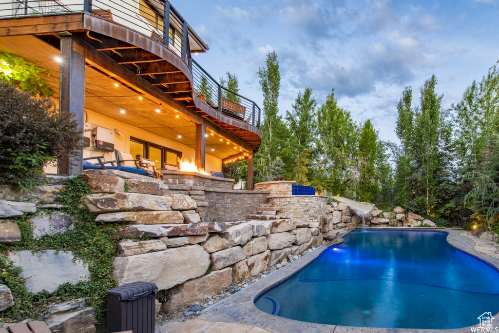 Pool at dusk featuring a patio