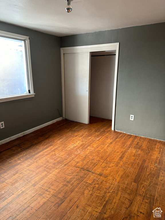 Unfurnished bedroom featuring a closet and hardwood / wood-style floors