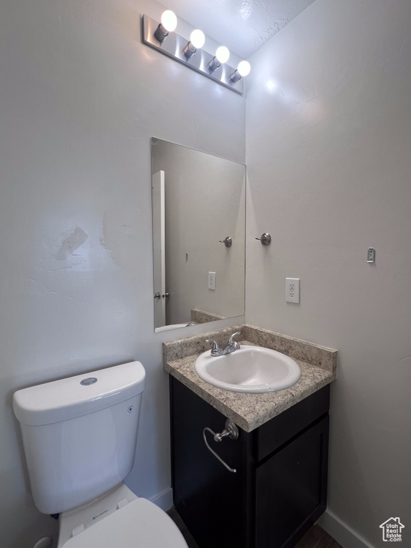 Bathroom featuring vanity, toilet, and a textured ceiling