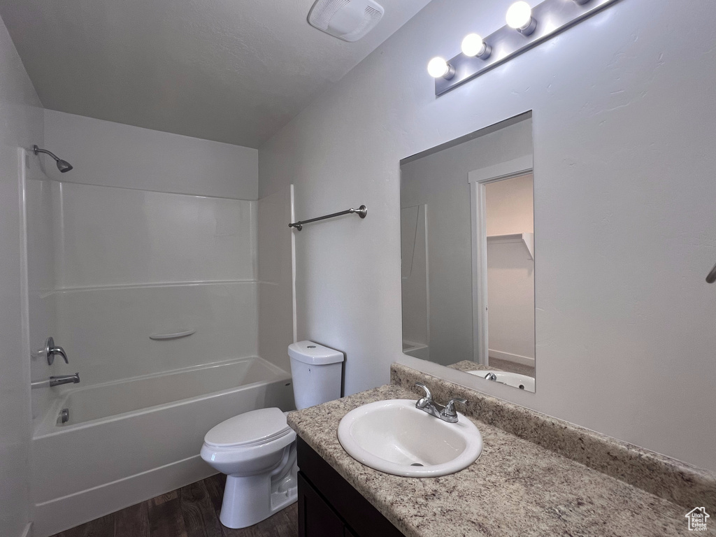 Full bathroom featuring vanity, shower / washtub combination, wood-type flooring, and toilet