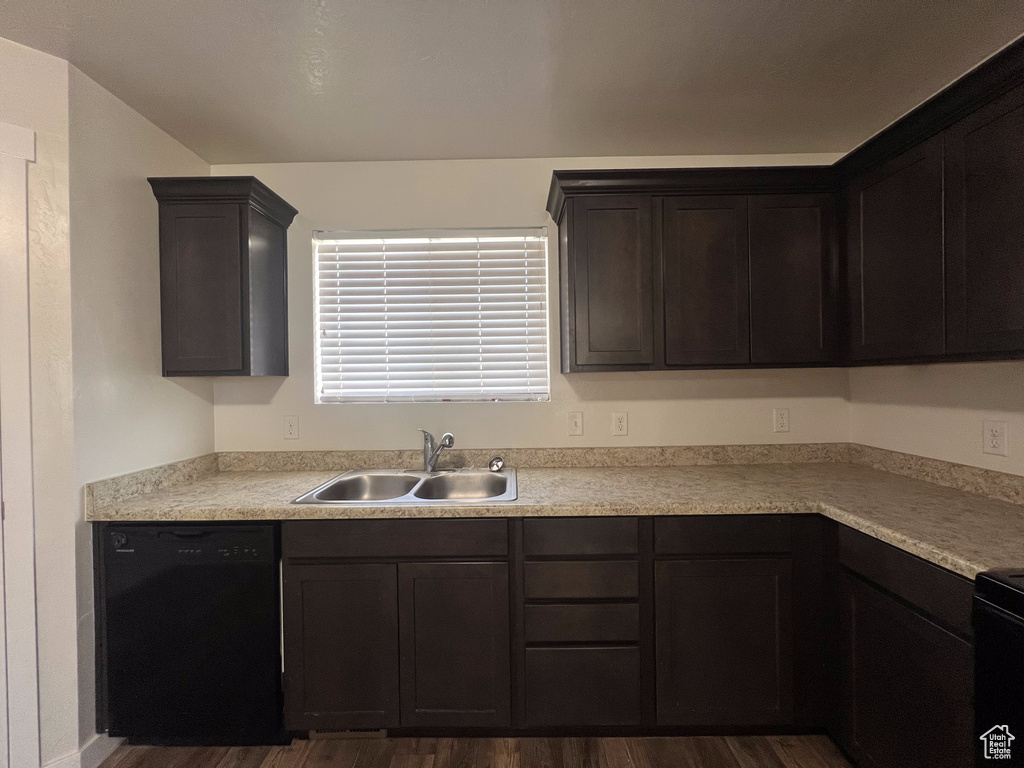 Kitchen with dishwasher, dark brown cabinetry, sink, and dark wood-type flooring