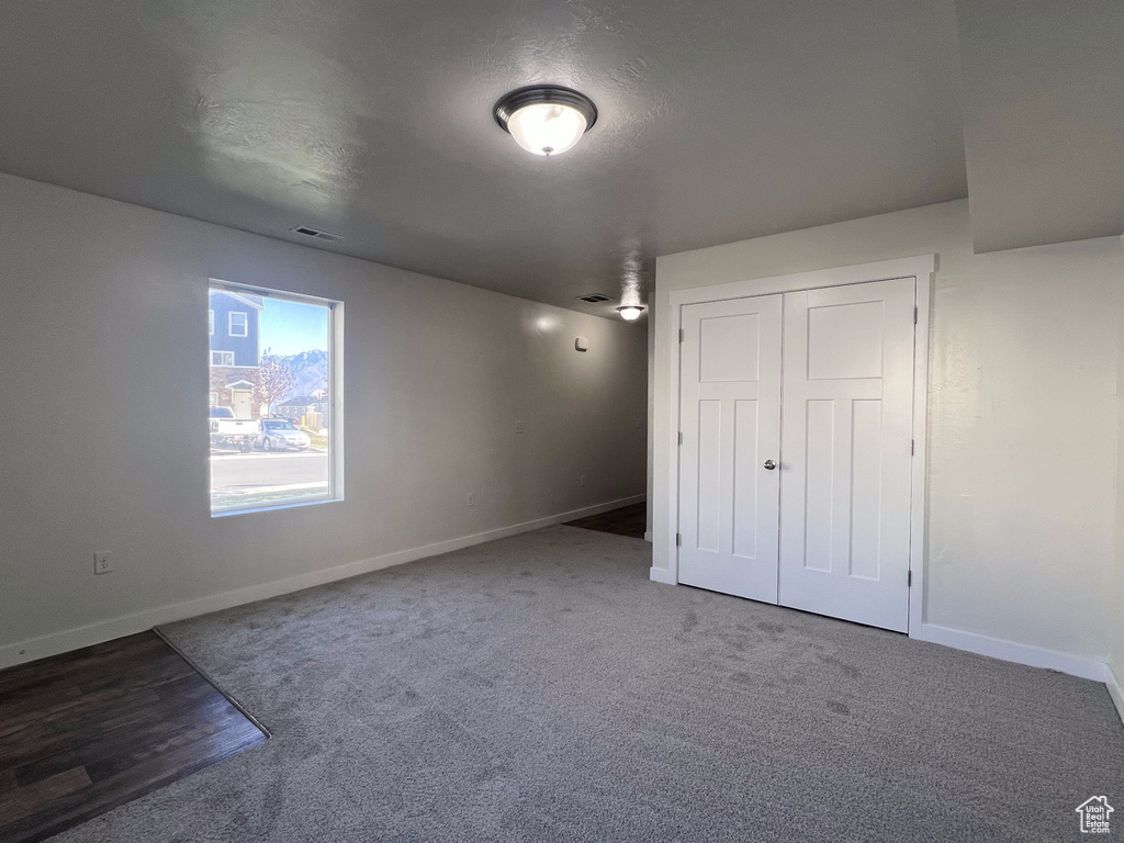 Unfurnished bedroom featuring a textured ceiling, carpet floors, and a closet