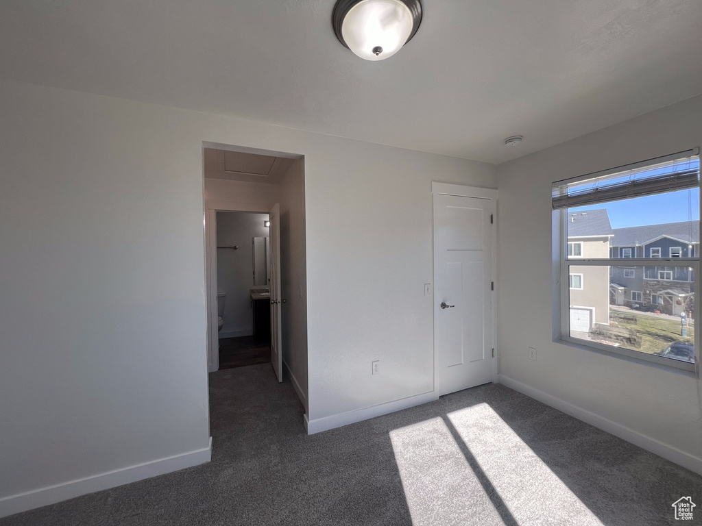 Unfurnished bedroom with dark colored carpet