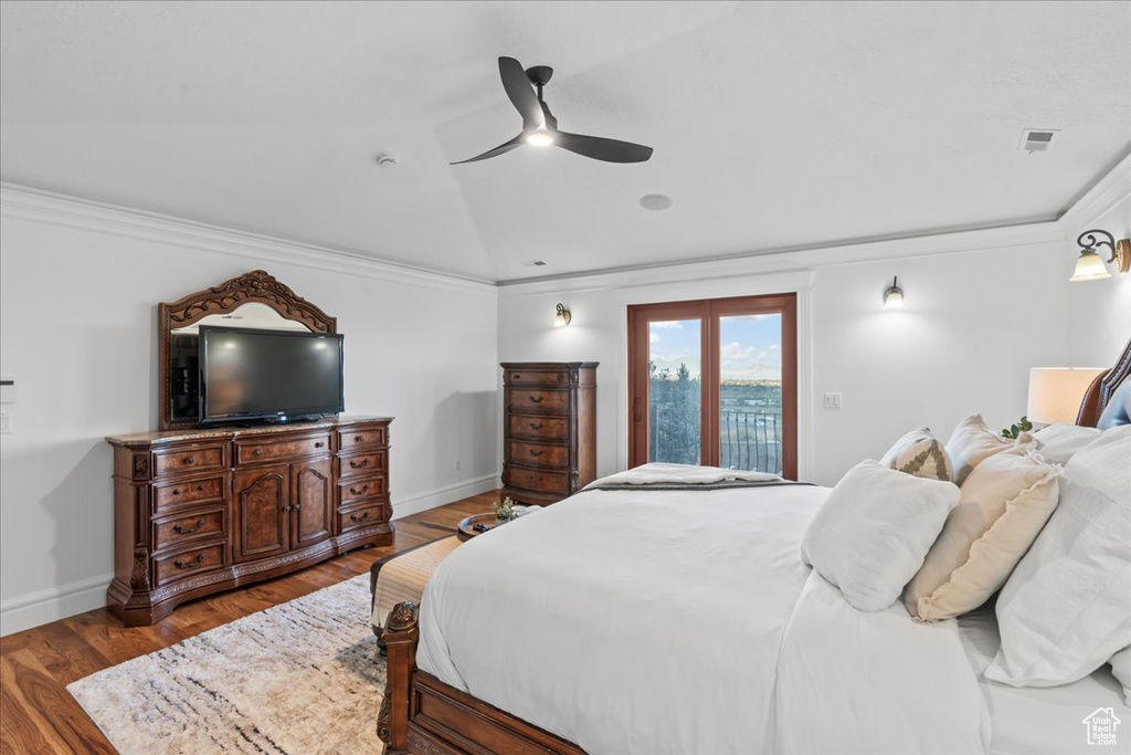 Bedroom featuring wood-type flooring, access to exterior, ceiling fan, lofted ceiling, and ornamental molding