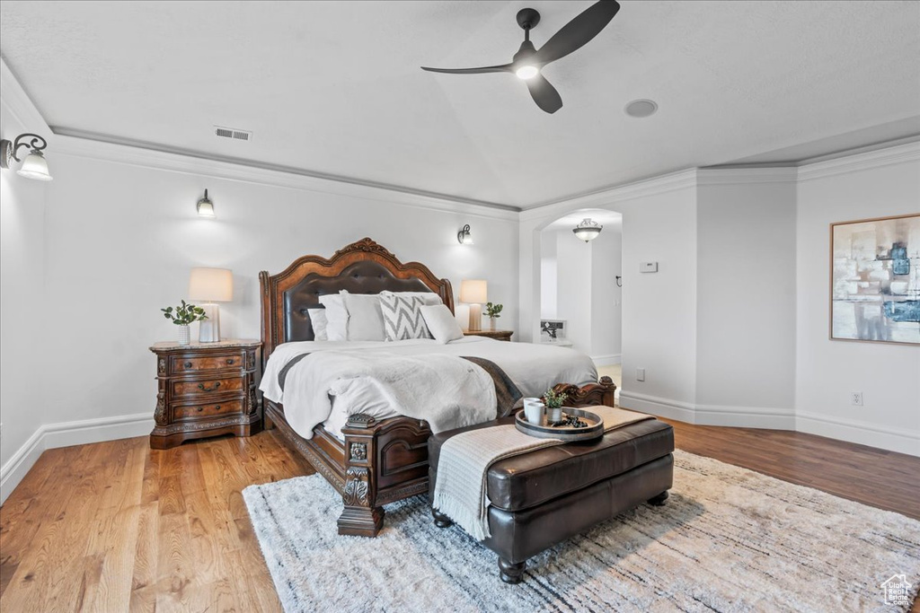 Bedroom featuring ornamental molding, light hardwood / wood-style flooring, and ceiling fan