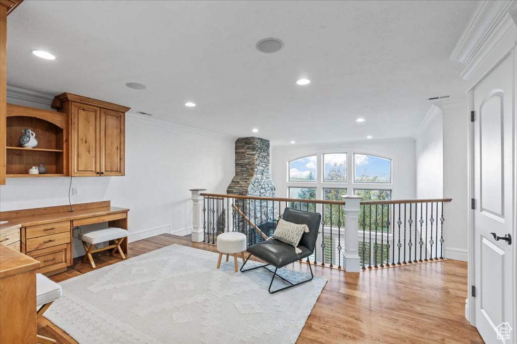 Living area featuring ornamental molding and light hardwood / wood-style flooring