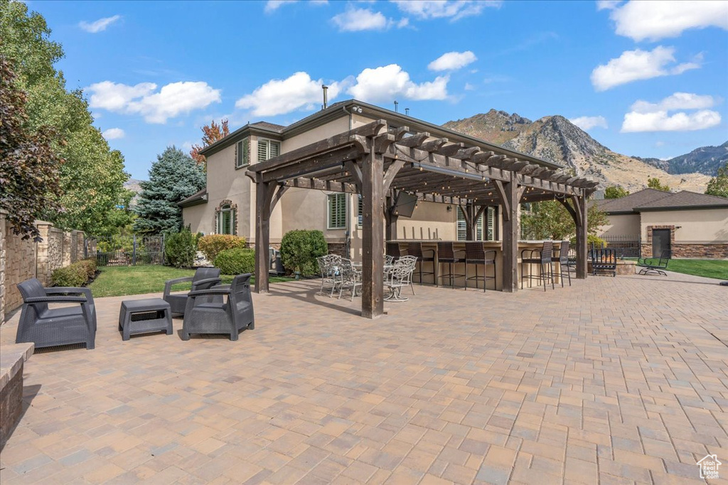 View of patio with a pergola, a mountain view, exterior bar, and outdoor lounge area