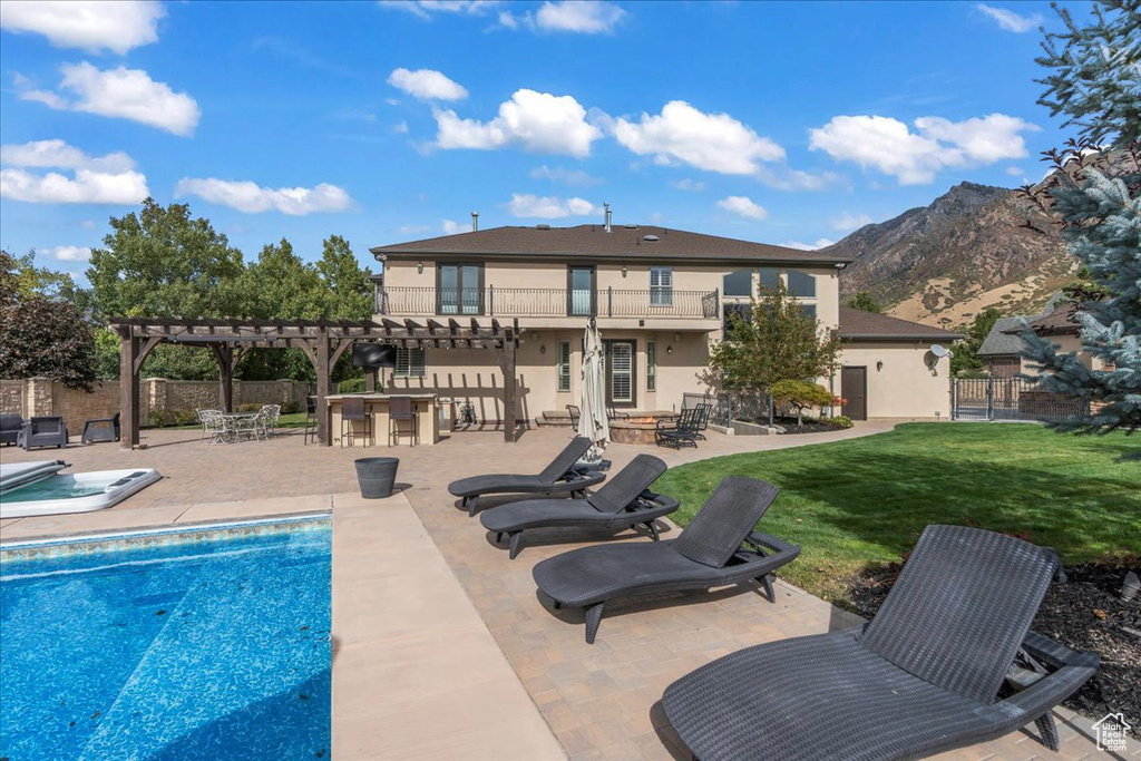 View of pool featuring a pergola, a patio, a mountain view, and a yard