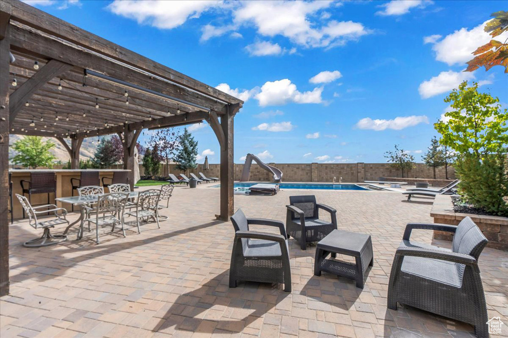 View of patio / terrace with a fenced in pool and a pergola