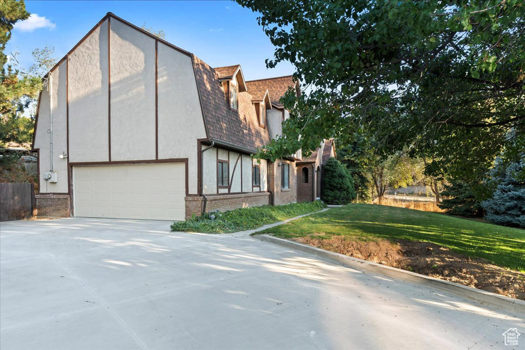 View of front of house with a front yard and a garage